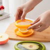 Reusable silicone cover keeping half a lemon fresh on a kitchen board