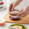 Reusable silicone food saver lid covering half a red onion to keep it fresh in the fridge