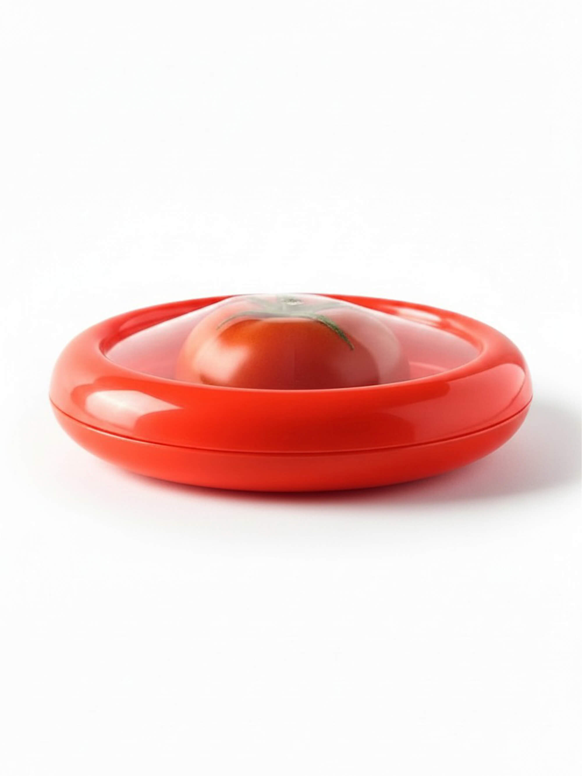 Reusable silicone tomato saver container storing half tomato with flexible seal lid on white background